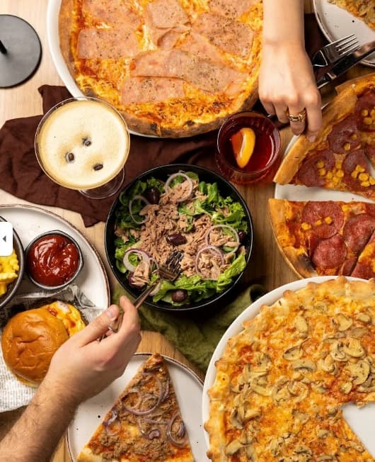 Gedeckter Tisch mit Pizza, Bowls und Getränken bei STERN*16